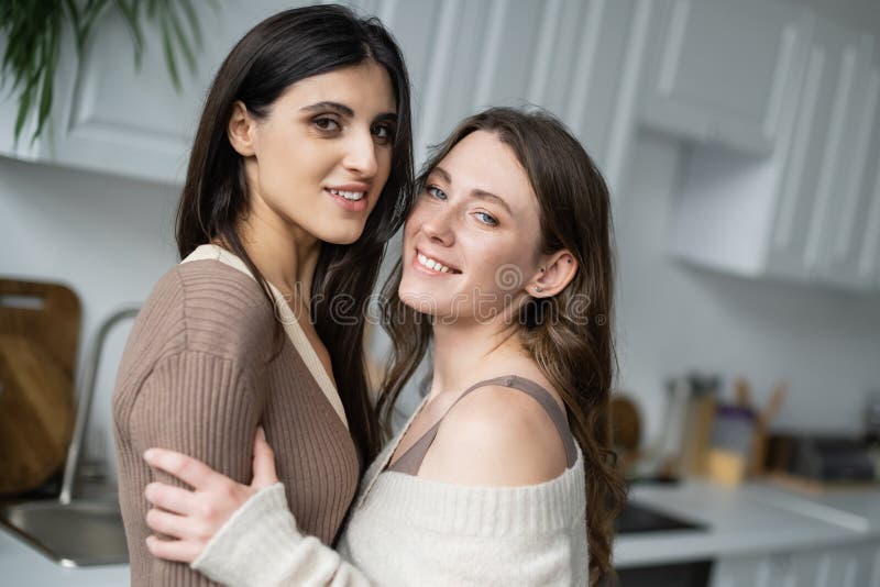 Selective Focus Of Smiling Lesbian Couple With Rainbow Flags Looking At Camera Lgbtq Community